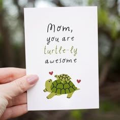 a hand holding up a card with a turtle on it's back that says mom, you are turtle - fly awesome