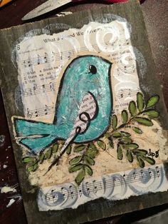 a blue bird sitting on top of a piece of paper with music notes and leaves