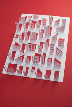 a red and white paper cut out with buildings in the middle by pixellli for stocks & bonds