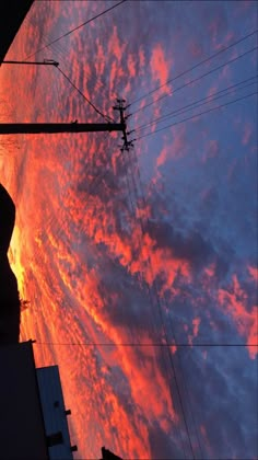 the sun is setting behind some power lines