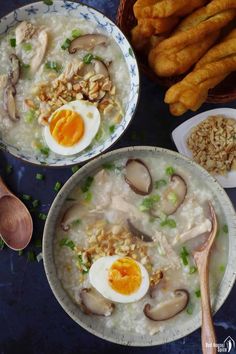 two bowls filled with rice, mushrooms and eggs next to some breadsticks on a table