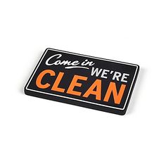 a black and orange sticker that says come in we're clean on it