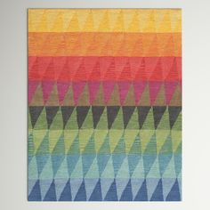 a multicolored rug with an abstract design on the front and back side, in different colors