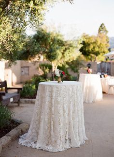 the table is set up outside for an outdoor wedding reception with white linens and flowers