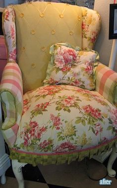 a chair that is upholstered with flowers and has pillows on the armrests