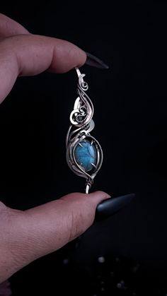 This cute pendant is woven of german silver. In the center of the jewelry is a cabochon of a blue labradorite stone. The stone sparkles very beautifully under the rays of light.  The pendant is made entirely by hand using the wire wrap technique. All curls are securely fixed, artificially darkened and polished to a mirror finish. Chain included. Select the chain length from the menu ATTENTION: Please note that In reality colors of jewelry may look slightly different than colors in photos on your screen. It depends on your monitor calibration and its color rendering. HOW TO CARE: Over time, the metal may darken slightly. It depends on the degree of contamination of the surface of the jewelry. It is very easy to clean metal with cloths for jewelry. Or rub thoroughly with a toothbrush with to Clean Metal, Labradorite Necklace, How To Clean Metal, Pendant For Women, Labradorite Necklaces, Blue Labradorite, Labradorite Pendant, Labradorite Stone, Bohemian Jewelry