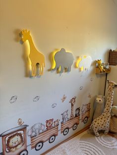 a child's room with animals and giraffes on the wall