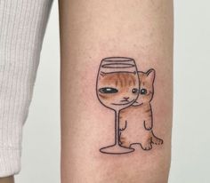 a cat and a wine glass tattoo on the arm