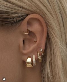 a close up of a person's ear with three different types of piercings