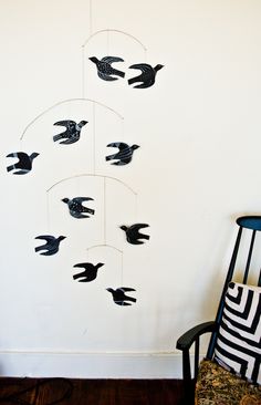 a black and white bird mobile hanging from a wall