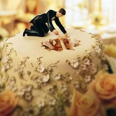 two figurines are placed on top of a wedding cake