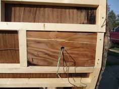 an unfinished wooden shelf with wires attached to the bottom and side panels that are missing