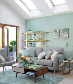 a living room filled with lots of furniture next to a glass wall door and skylight