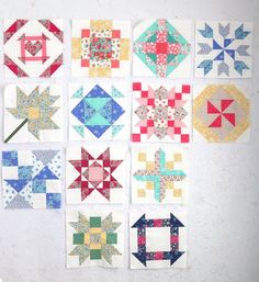 nine quilt blocks are arranged in rows on a white surface, each with different designs