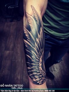 a man with a tattoo on his arm that has an angel wings design on it