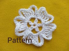 a crocheted flower is shown on a yellow surface with the words pattern below it