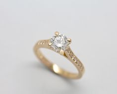 a yellow gold ring with a diamond in the center