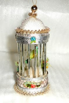 a decorative birdcage is sitting on a white surface