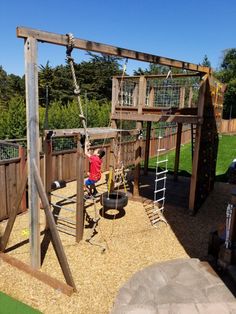 a child playing on a wooden swing set