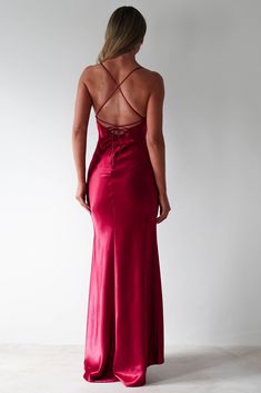 Ideal for formal events, debs, prom and even date nights where you want to make a bold statement, this dress is your ultimate show-stopper. Featuring a sleek, body-skimming silhouette and a thigh-high slit, it exudes confidence and style. The delicate spaghetti straps and subtle cowl neckline add a touch of romance, while the luxurious satin fabric catches the light beautifully. Highlights Figure slimming slip dress with straight neckline Low back with adjustable tie straps Soft feeling fabric A Red Grad Dress, Red Maxi Dress With Tie Back, Red Satin Maxi Gown, Fitted Red Satin Maxi Dress, Red Floor-length Satin Prom Dress, Red Satin A-line Maxi Dress, Hoi An Tailor, Prom Dance, Satin Formal Dress