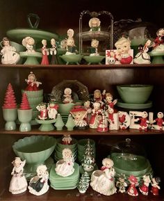 a shelf filled with green dishes and christmas figurines on top of each other