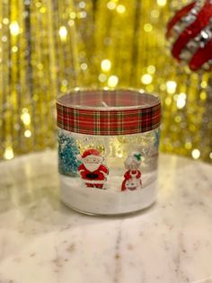 a glass jar sitting on top of a table next to a christmas ornament