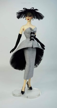 a mannequin wearing a gray dress and black gloves