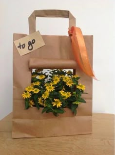 a brown paper bag with yellow flowers in it and a tag on the handle that says, $ 99