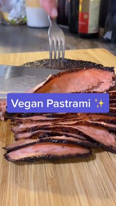 a person cutting up some meat on top of a wooden cutting board with a fork