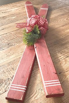 a wooden cross with a red bow on it sitting on top of a wood floor