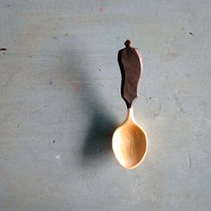 a wooden spoon with some sort of brown substance on top of it, sitting on a concrete surface