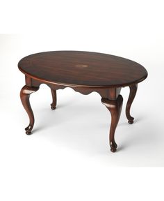 an oval wooden table with carved legs