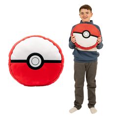 a young boy is holding up a pillow with a pokeball on it and smiling at the camera