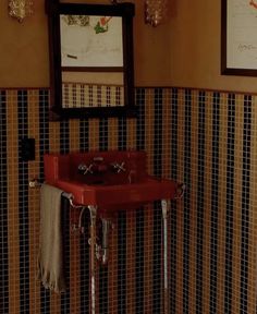 a red sink sitting under two mirrors in a bathroom next to a wall mounted faucet