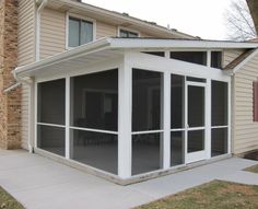 an enclosed patio with sliding glass doors in front of a house