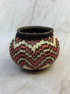 a black and red basket sitting on top of a white table