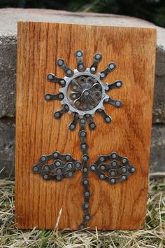 a wooden box with metal designs on it sitting in the grass next to a stone wall