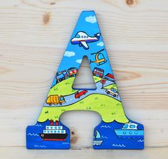 a wooden letter shaped like a train, boat and airplane