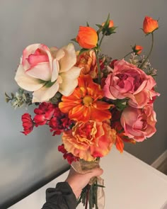 a person holding a bouquet of flowers in their hand