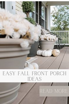 the front porch is decorated with white flowers and pumpkins