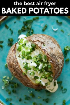 the best air fryer baked potatoes on a blue plate with green onions and sour cream