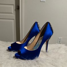 a pair of blue high heeled shoes sitting on top of a white rug