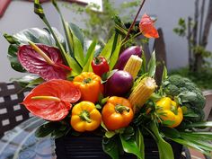 a basket filled with lots of different types of fruits and vegetables on top of a table