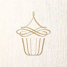 a cupcake with an artistic design on the front and side, drawn in gold ink