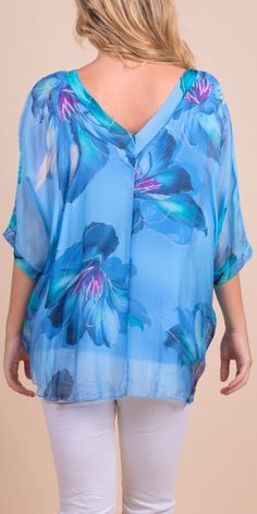 Floral Bloom Design on 100% Silk Blouse with Frayed Raw Edge Hemline. Soft, Stretchy Viscose Layer Underneath. 100% Silk Exterior | 95% Viscose | 5% Elastic Interior Made in Italy Fits Sizes XS- XL Model 5'7 Blue Floral Print V-neck Blouse, Light Blue Printed V-neck Top, Blue Flowy V-neck Top, Light Blue Floral Print V-neck Top, Blue Floral Print Top With Relaxed Fit, Blue Floral Print Relaxed Fit Tops, Light Blue V-neck Blouse With Floral Print, Light Blue V-neck Blouse For Daywear, Blue V-neck Shirt For Spring