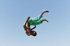 a man in the air doing a trick on a skateboard with his feet up