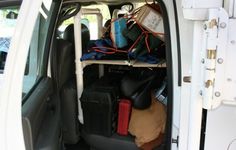 the back end of a white van filled with luggage