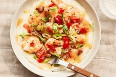 a bowl filled with shrimp and vegetables on top of mashed potatoes