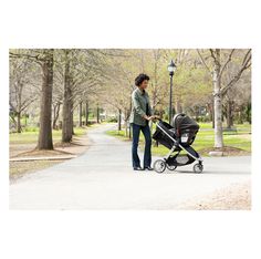 a woman pushing a stroller in the park