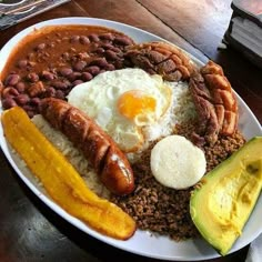 a white plate topped with eggs, beans and sausage